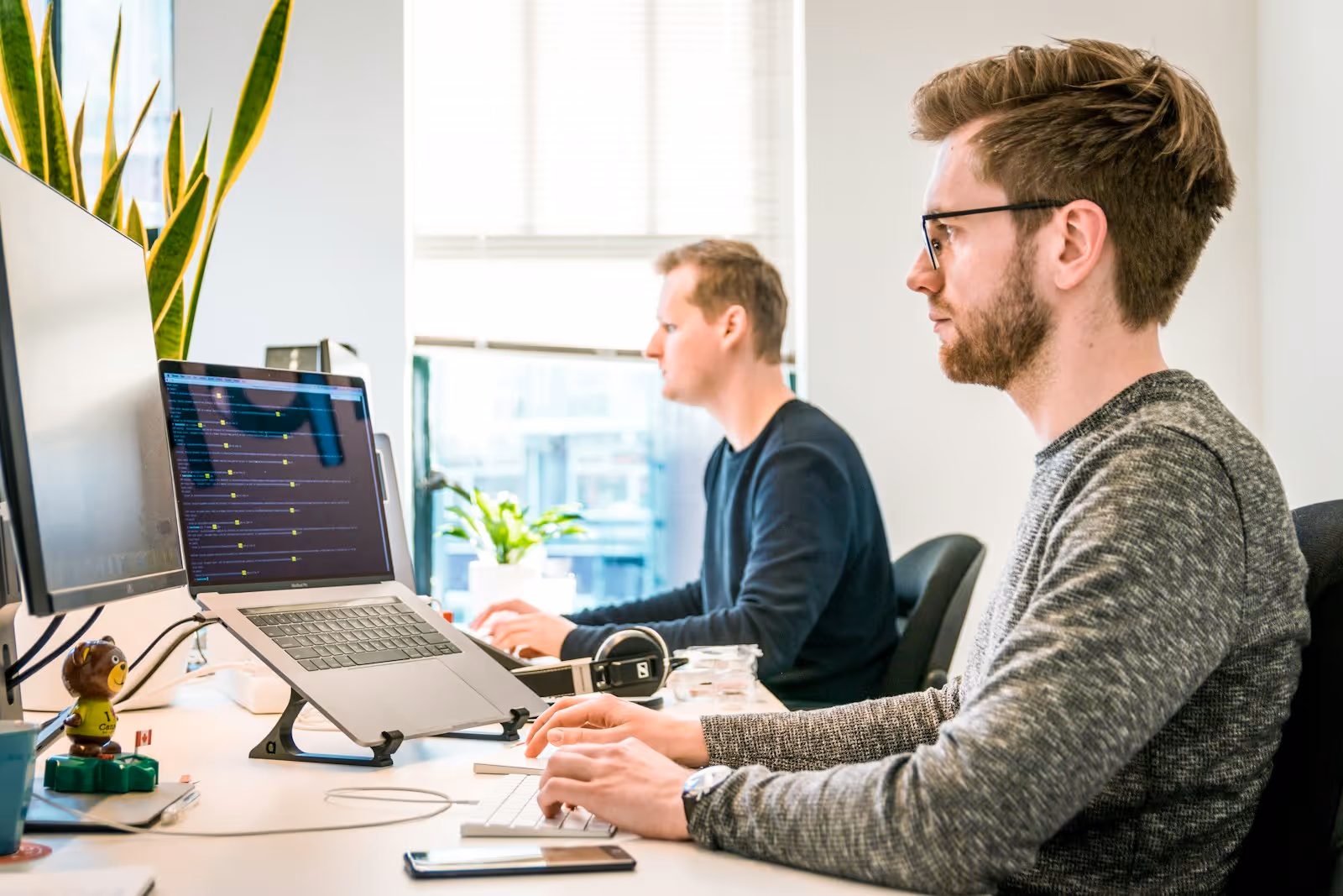 Two professionals reviewing a workflow assessment on a laptop